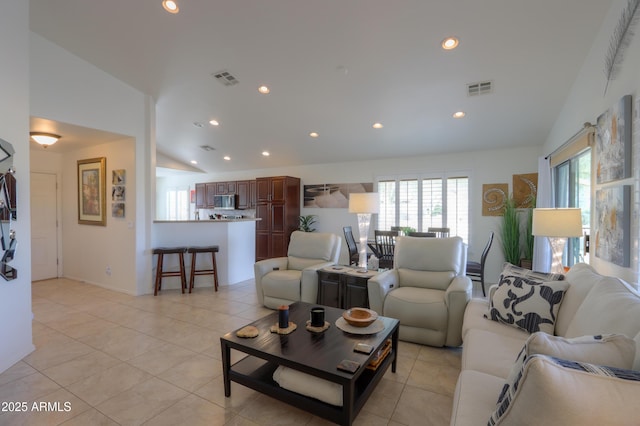 living room with light tile patterned floors and vaulted ceiling