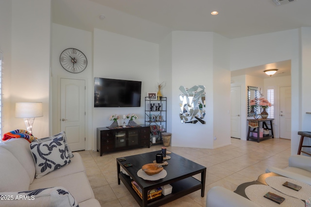 living room featuring light tile patterned floors and a high ceiling