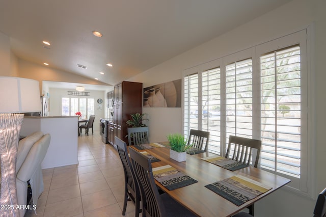 dining room featuring lofted ceiling and light tile patterned floors