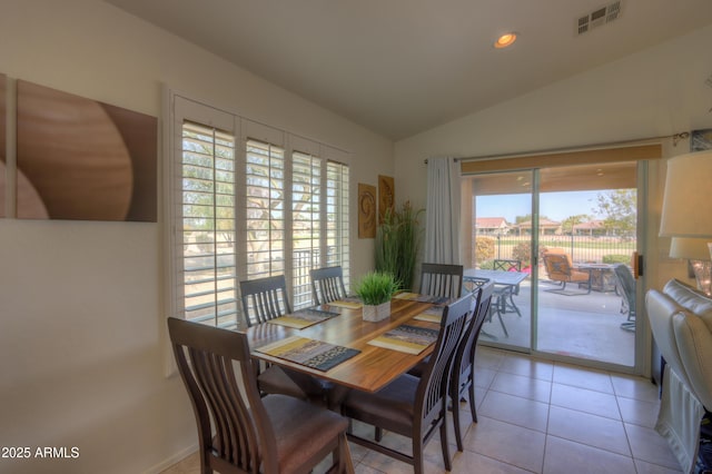 tiled dining space with vaulted ceiling