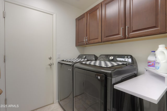 laundry room with cabinets, separate washer and dryer, and light tile patterned floors