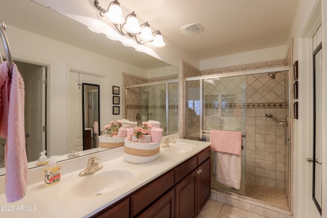 bathroom with tile patterned floors, a shower with door, and vanity