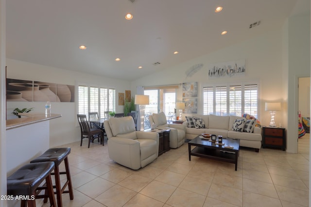 living room with high vaulted ceiling and light tile patterned floors