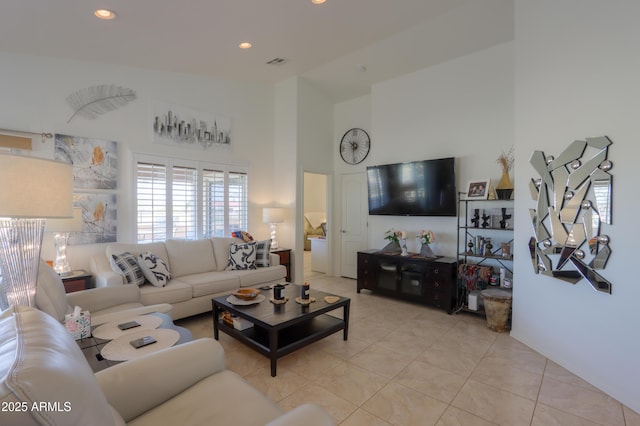 living room with light tile patterned flooring and a high ceiling