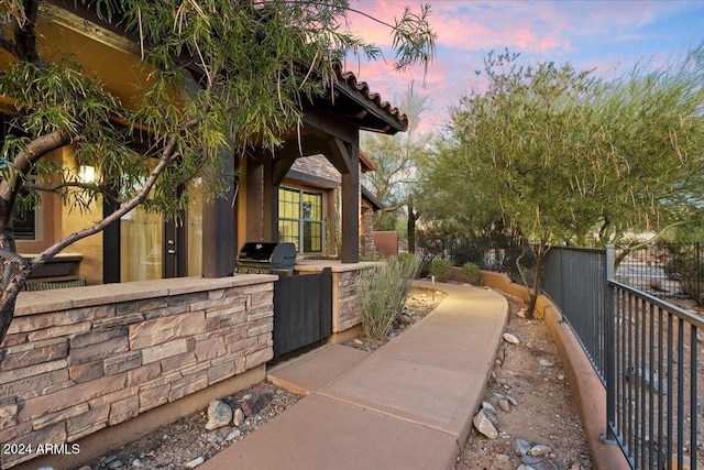 property exterior at dusk featuring exterior kitchen