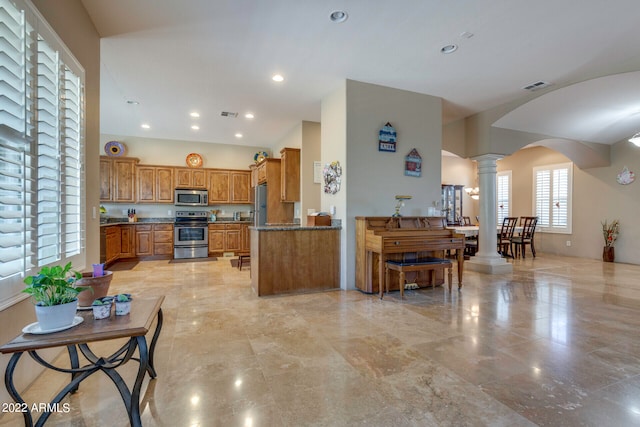 kitchen featuring appliances with stainless steel finishes, light tile floors, ornate columns, and plenty of natural light