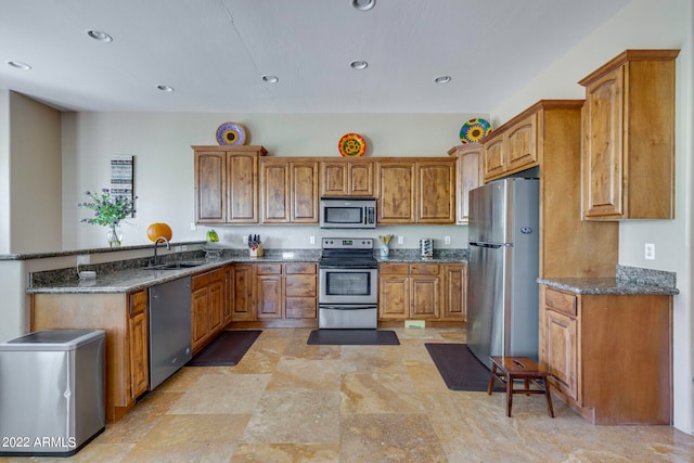 kitchen featuring dark stone countertops, appliances with stainless steel finishes, light tile floors, and sink