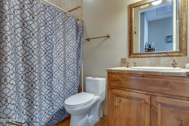 bathroom with vanity, toilet, and tasteful backsplash