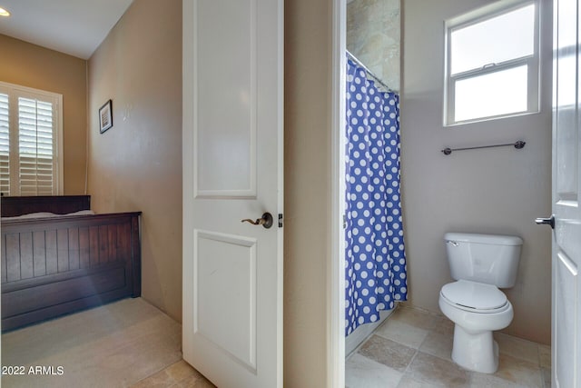 bathroom featuring tile flooring and toilet