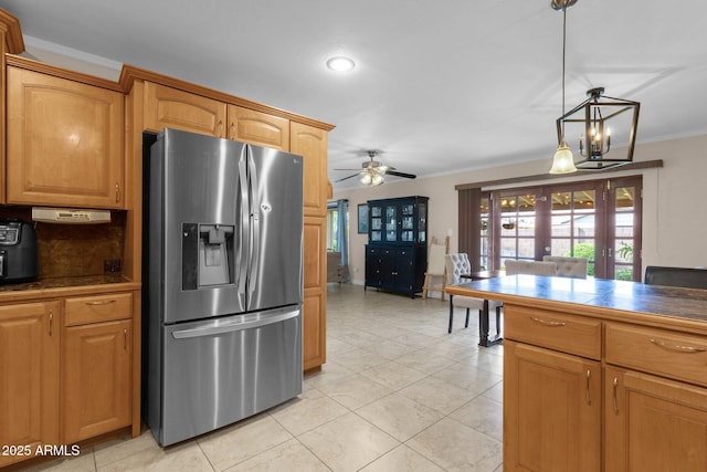 kitchen featuring dark countertops, stainless steel fridge with ice dispenser, french doors, ceiling fan with notable chandelier, and ornamental molding