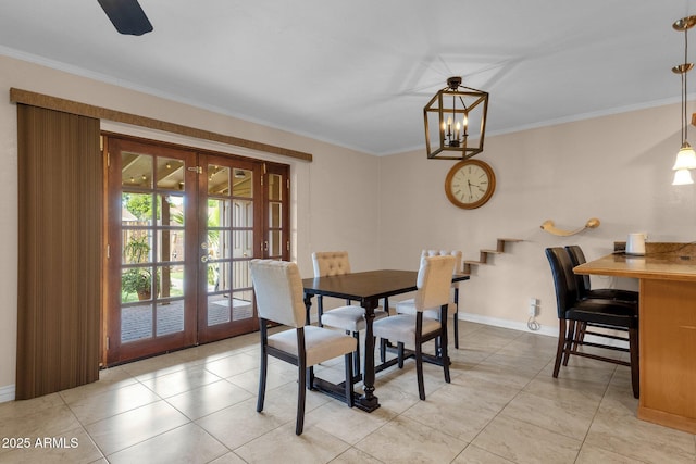 dining space with french doors, ornamental molding, baseboards, and a notable chandelier