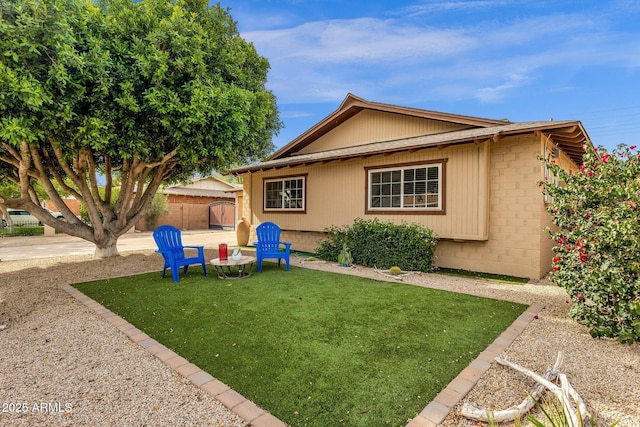 view of home's exterior featuring a lawn, fence, and brick siding