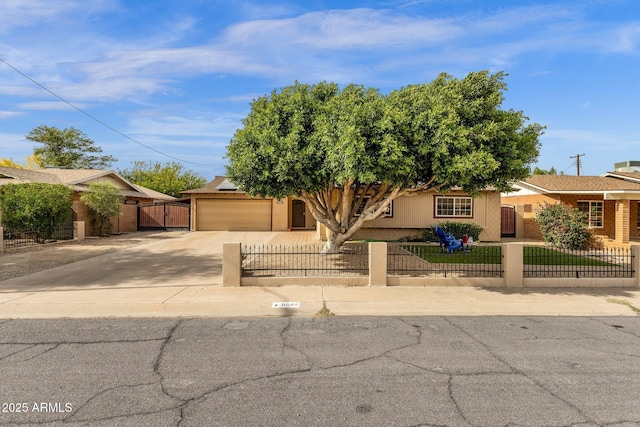 view of front facade featuring a gate, a fenced front yard, an attached garage, and driveway