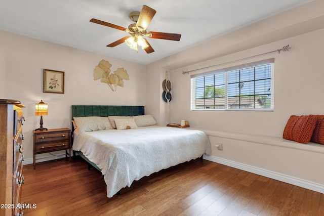 bedroom with baseboards, ceiling fan, and wood finished floors
