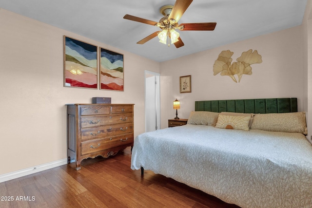bedroom featuring baseboards, a ceiling fan, and wood finished floors