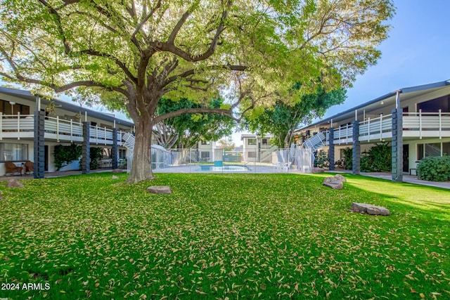 view of property's community featuring a yard and a swimming pool