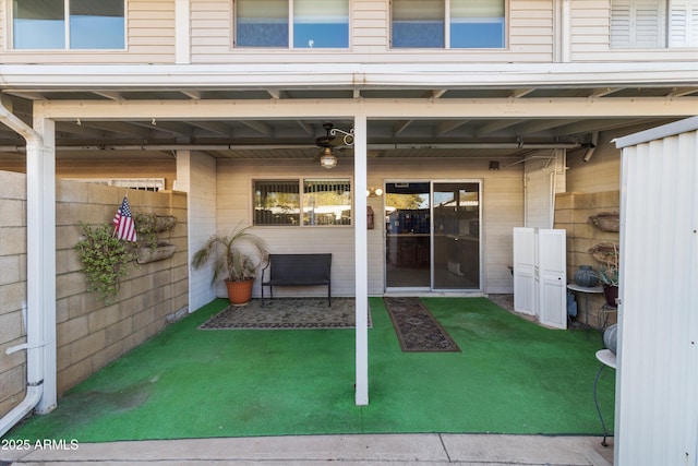 entrance to property featuring a lawn and ceiling fan