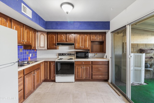 kitchen with light tile patterned flooring, white appliances, tasteful backsplash, and sink