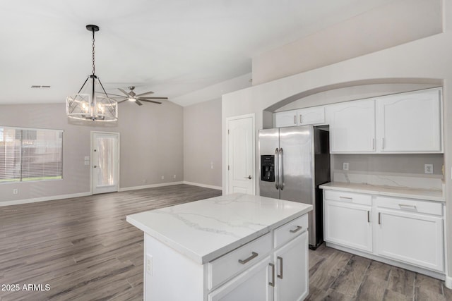 kitchen featuring lofted ceiling, hanging light fixtures, stainless steel refrigerator with ice dispenser, and white cabinets