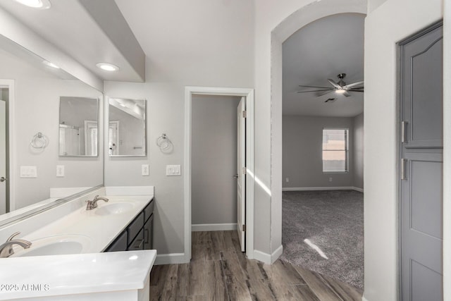 full bathroom with ceiling fan, wood finished floors, a sink, baseboards, and double vanity