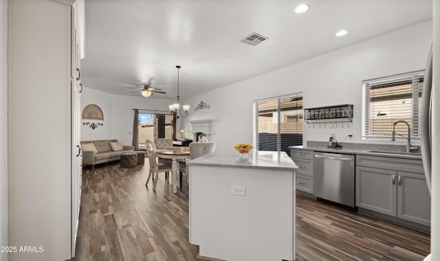 kitchen with sink, gray cabinets, hanging light fixtures, a kitchen island, and stainless steel dishwasher