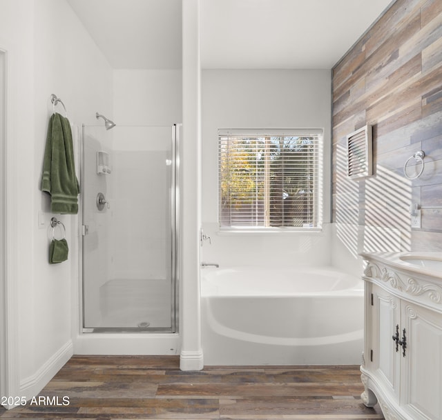 bathroom featuring vanity, hardwood / wood-style flooring, and plus walk in shower