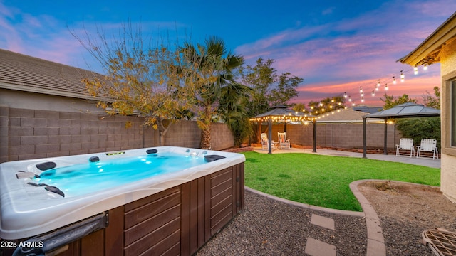 pool at dusk featuring a gazebo, a patio, a hot tub, and a lawn