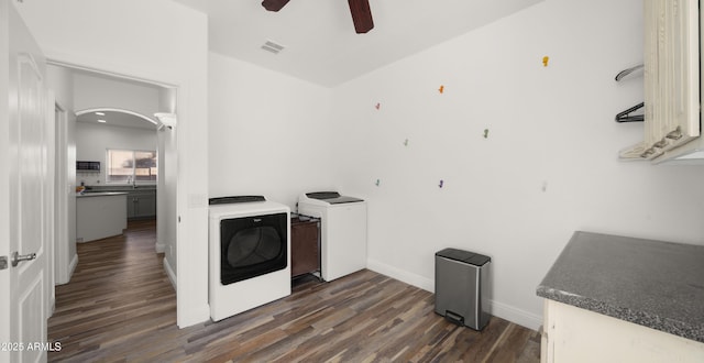 clothes washing area with washing machine and dryer, ceiling fan, and dark hardwood / wood-style flooring