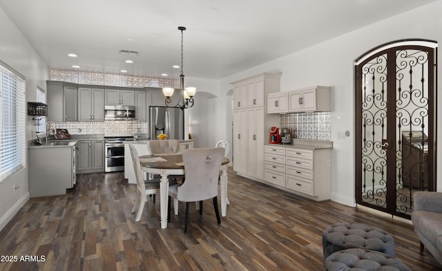 dining space with sink, a chandelier, and dark hardwood / wood-style flooring