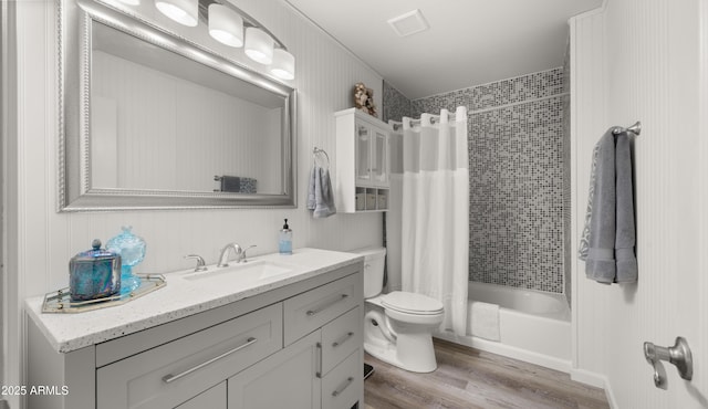 full bathroom featuring hardwood / wood-style flooring, vanity, toilet, and shower / tub combo