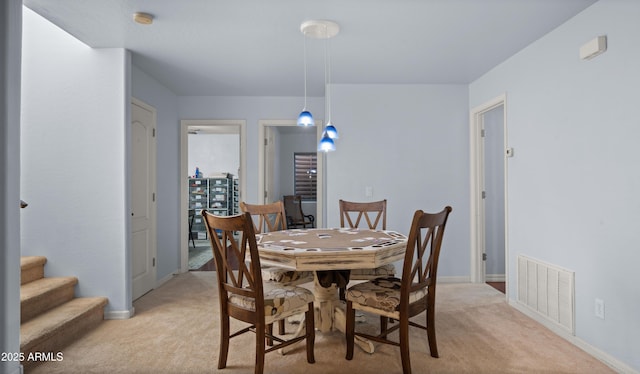 dining space featuring light carpet