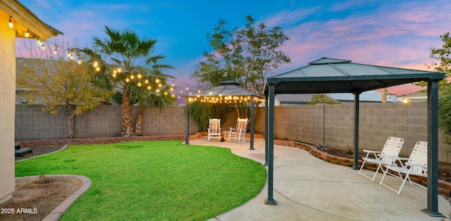 yard at dusk featuring a gazebo and a patio area