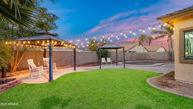 yard at dusk featuring a gazebo and a patio