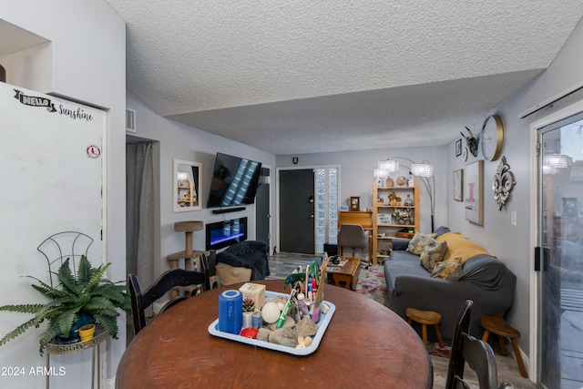 dining room featuring vaulted ceiling and a textured ceiling