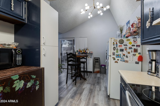 kitchen with hardwood / wood-style flooring, blue cabinets, a textured ceiling, and vaulted ceiling