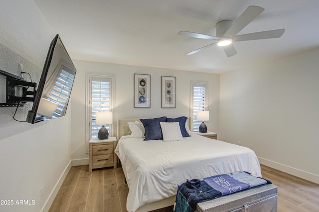 bedroom with multiple windows, light hardwood / wood-style floors, and ceiling fan