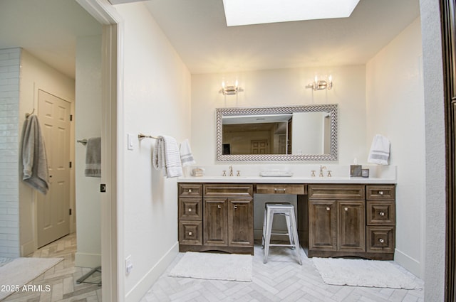 bathroom featuring parquet floors, vanity, and a skylight