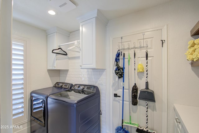 laundry area with separate washer and dryer and cabinets