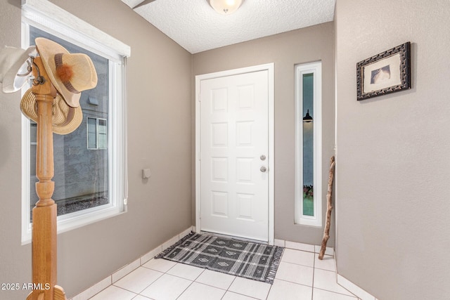 entryway featuring light tile patterned floors and a textured ceiling