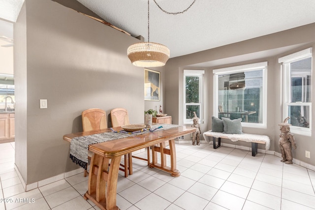 dining room featuring light tile patterned flooring, sink, and a textured ceiling