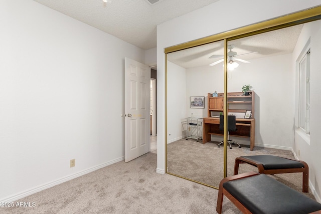 office area featuring ceiling fan, light colored carpet, and a textured ceiling