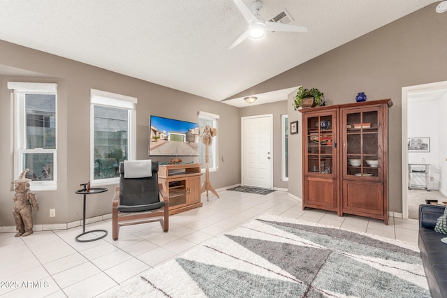 tiled office featuring ceiling fan, lofted ceiling, and a textured ceiling