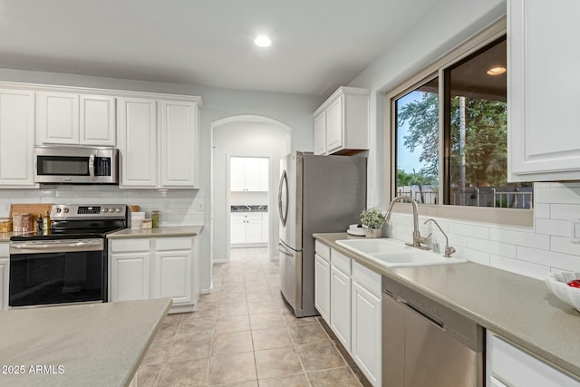 kitchen with sink, white cabinetry, light tile patterned floors, and appliances with stainless steel finishes