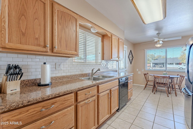 kitchen featuring sink, light tile patterned floors, black dishwasher, tasteful backsplash, and light stone countertops