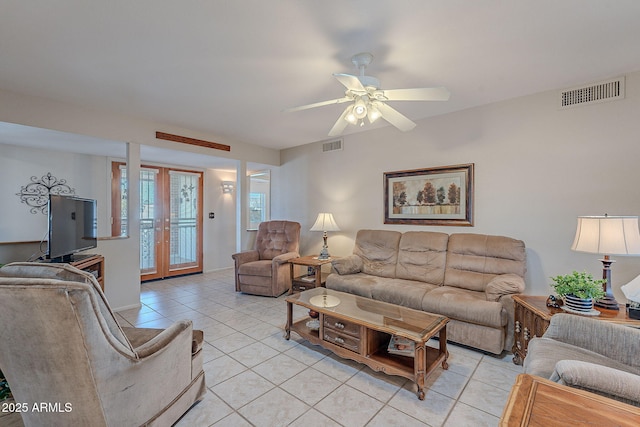 tiled living room with ceiling fan and french doors