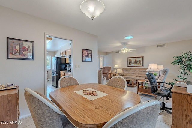 dining space featuring ceiling fan and light tile patterned floors