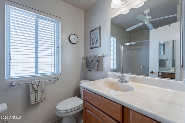 bathroom with ceiling fan, vanity, toilet, and a shower with shower door