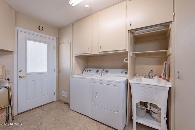 laundry area featuring cabinets, washing machine and dryer, and sink