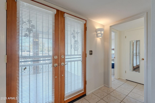 doorway with light tile patterned floors and french doors