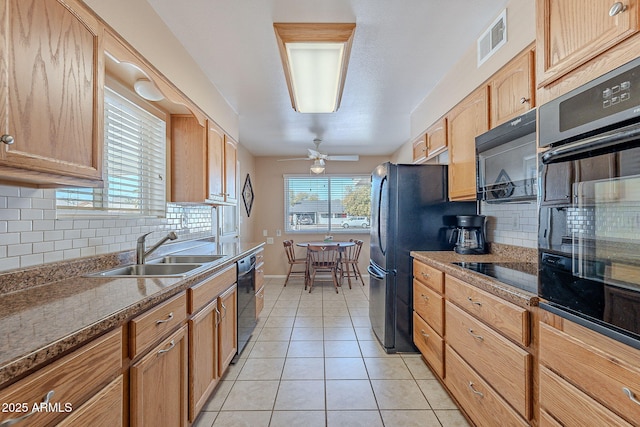 kitchen with a healthy amount of sunlight, sink, light tile patterned floors, and black appliances